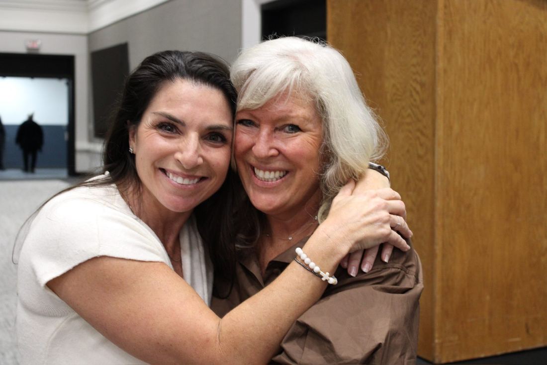 Two women sharing a big hug after the program